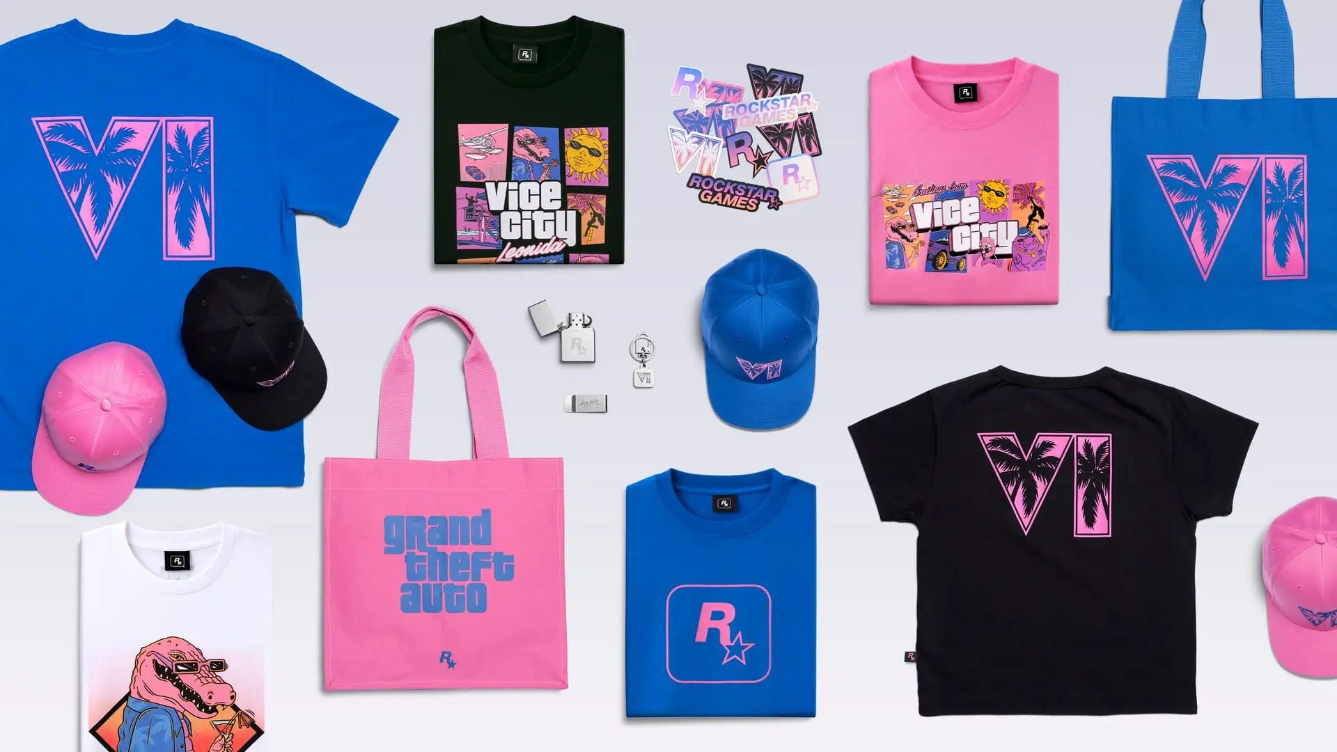 Flat-lay of Grand Theft Auto VI merchandise: blue and pink T-shirts, caps, tote bags, a lighter and a Rockstar tee.